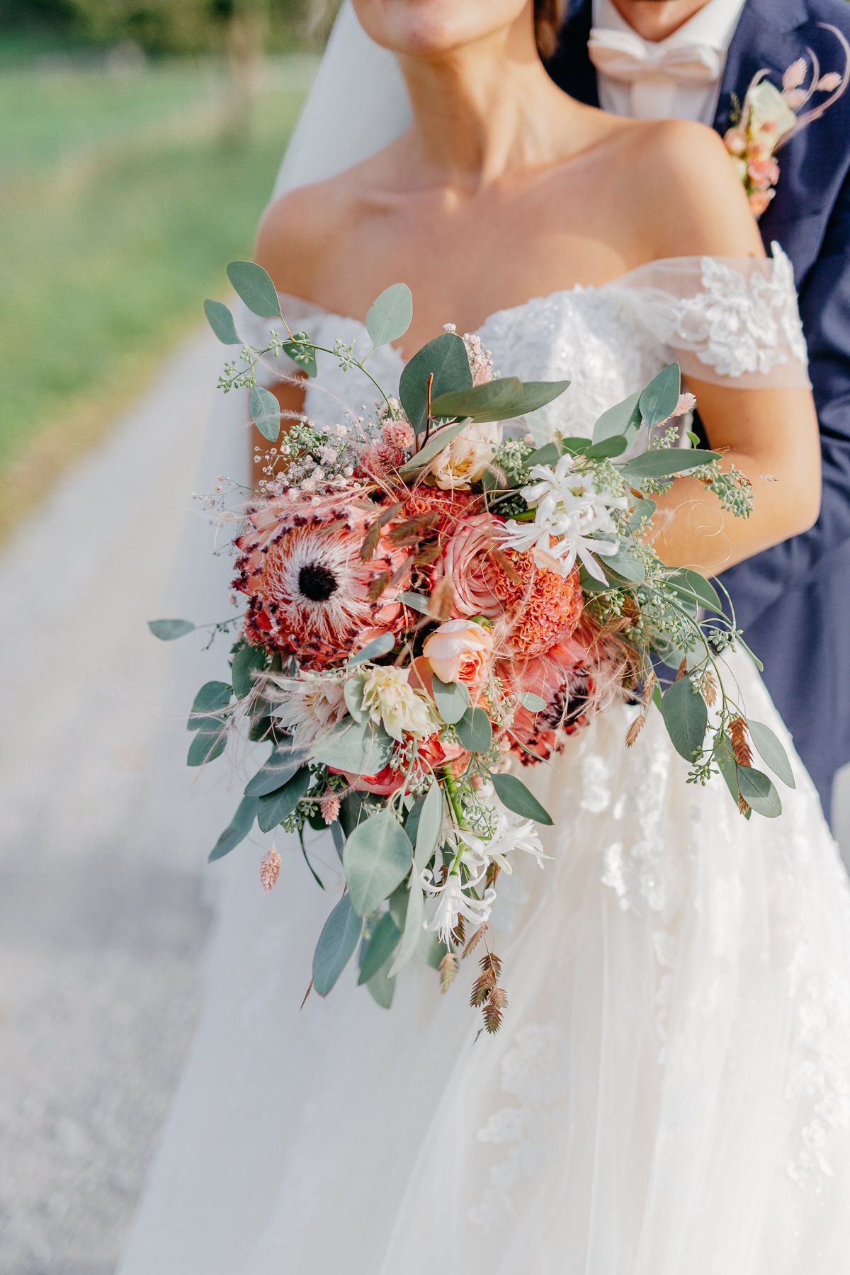 Die Braut hält einen farbenfrohen Brautstrauß mit Eukalyptus.
