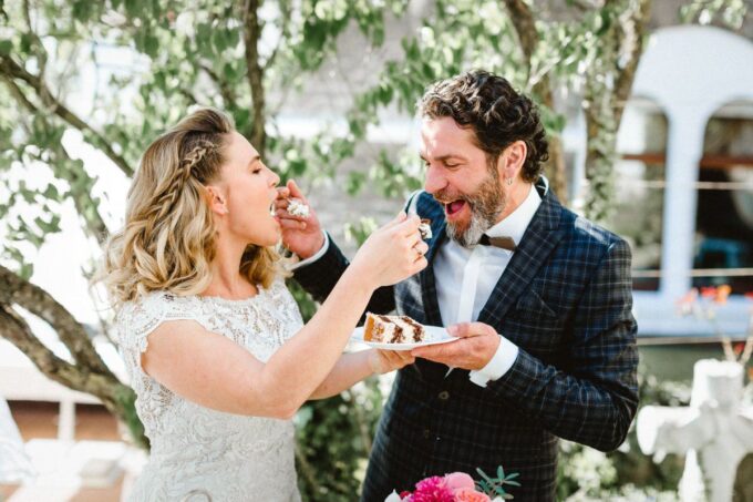 Eine Braut und ein Bräutigam füttern sich gegenseitig mit Kuchen.