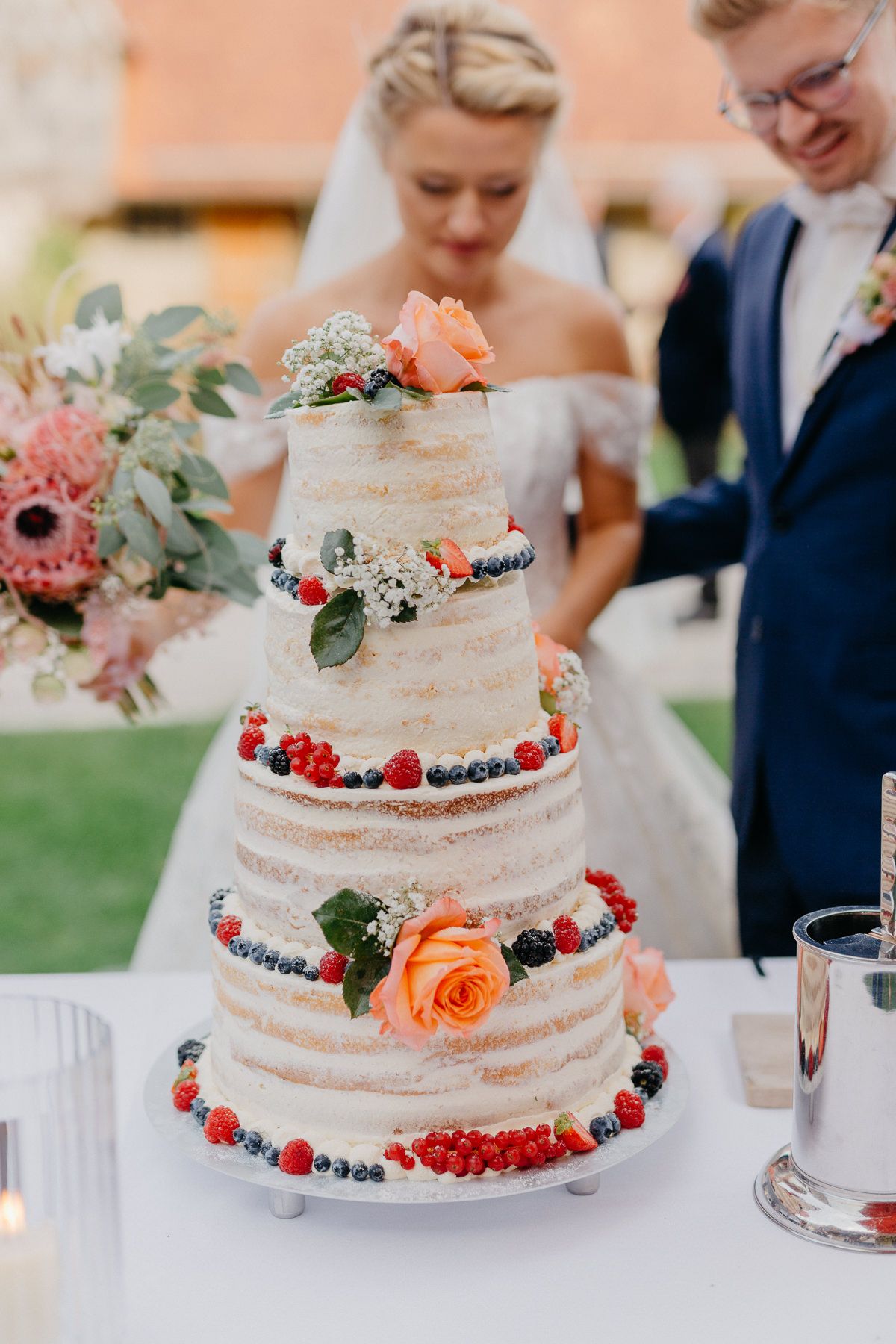 Semi-Naked Cake mit Beeren - Brautpaar im Hintergrund