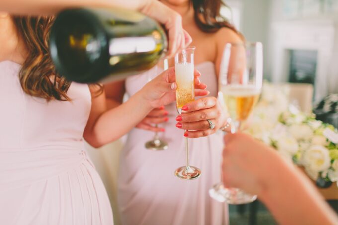 Brautjungfern gießen Champagner in Gläser.