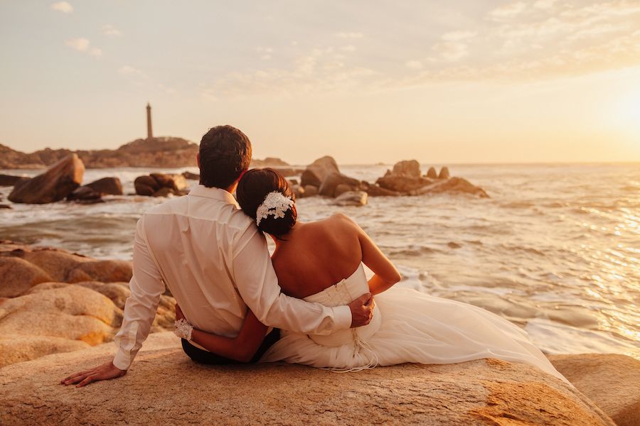 Paar in Hochzeitsoutfits am Meer