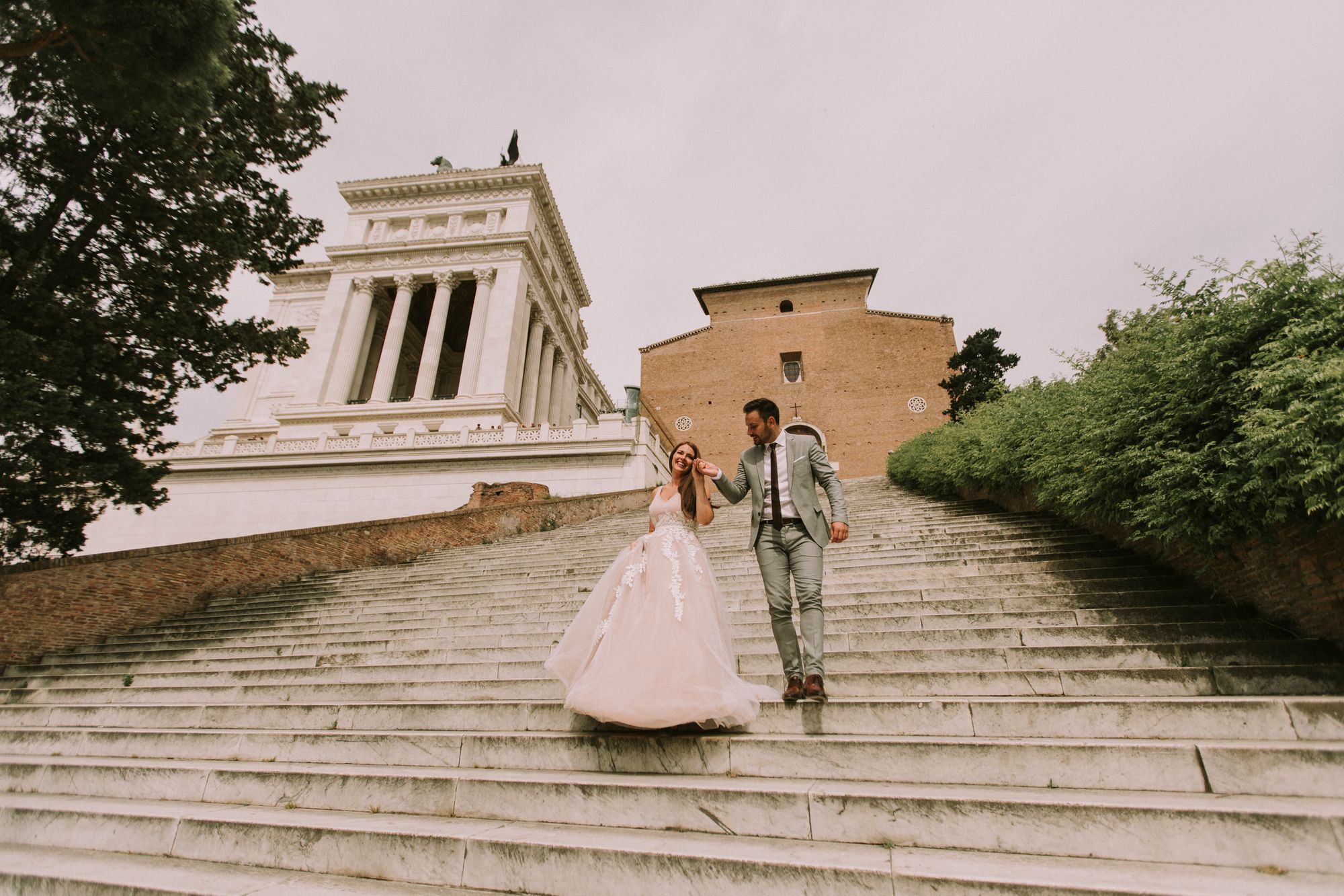 Eine Braut und ein Bräutigam gehen die Stufen eines Gebäudes hinunter.