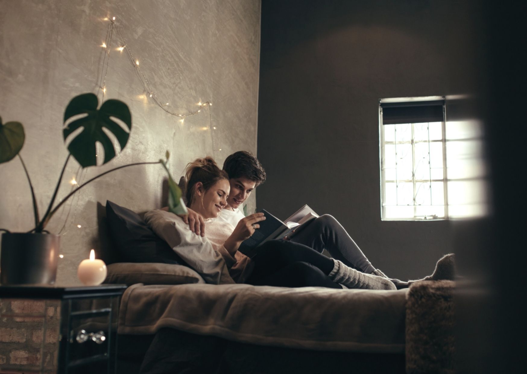 Paar schaut sich gemeinsam ein Buch mit Sprüchen an