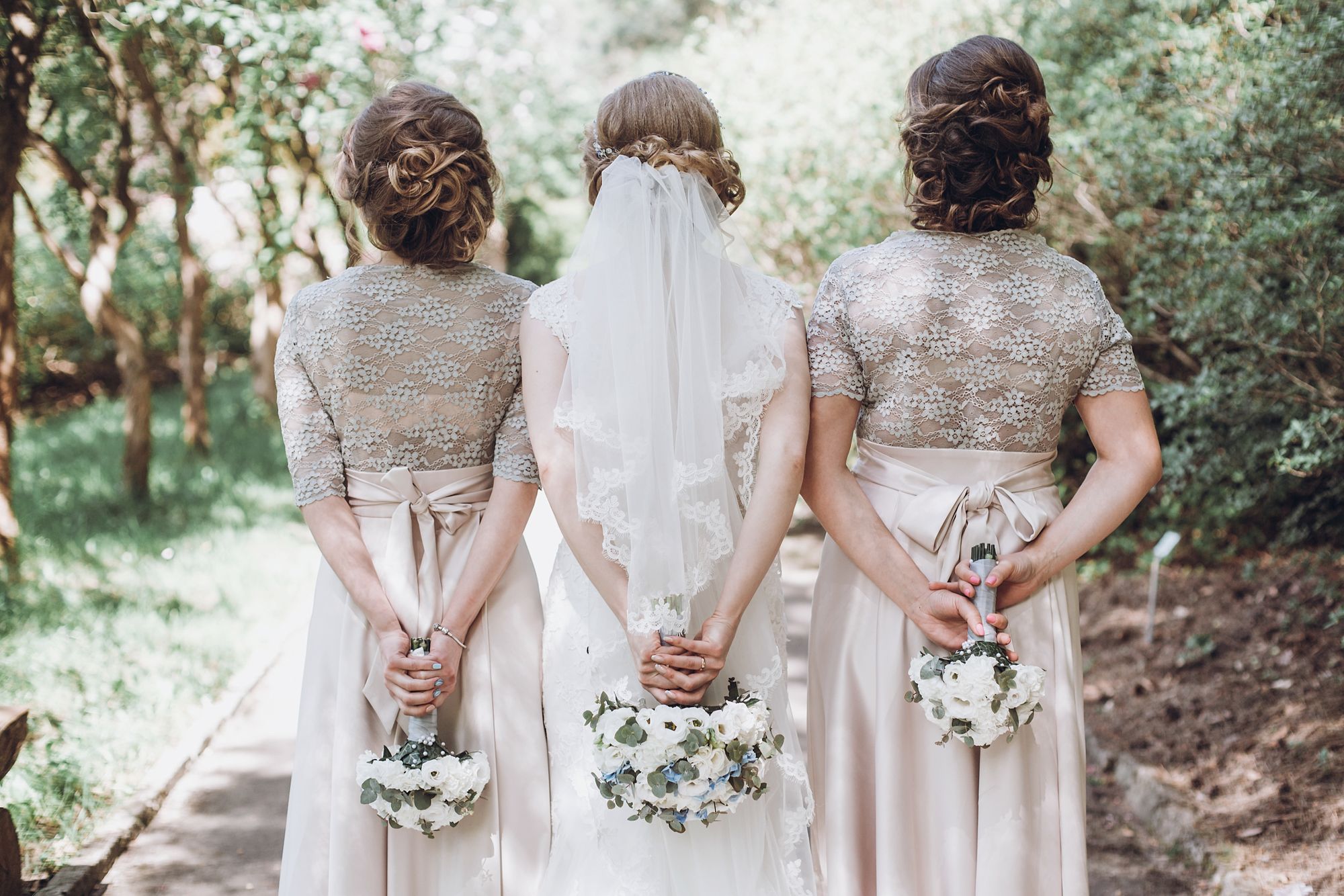 Braut mit Trauzeuginnen und Blumensträußen