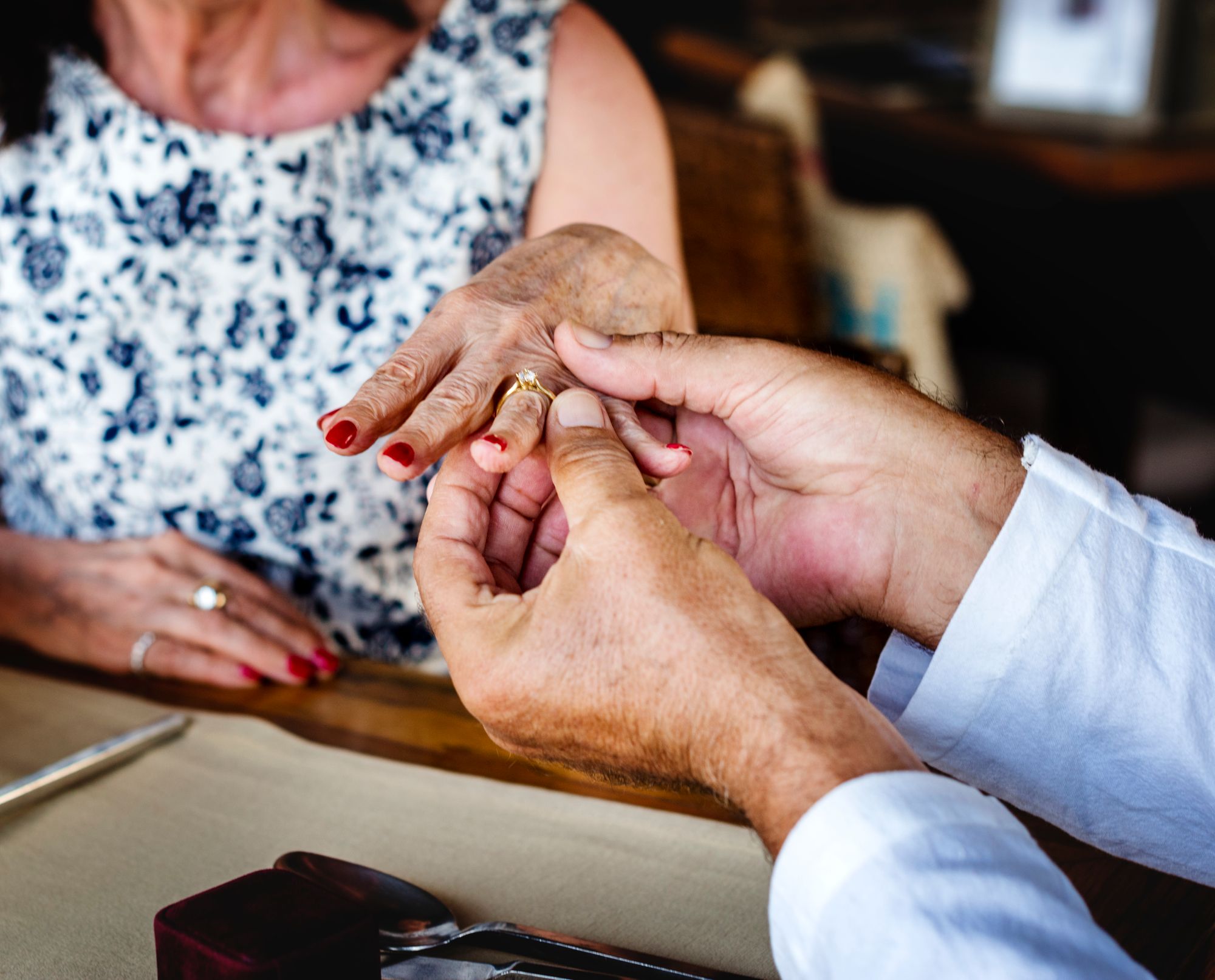 Ein Mann steckt einer Frau einen Ring an den Finger.