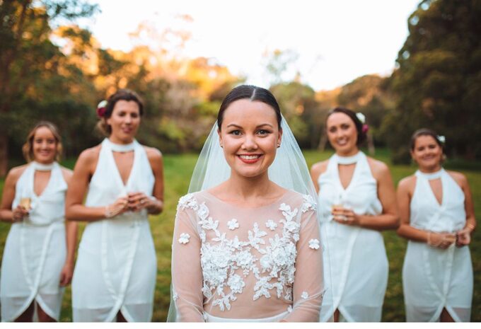 Eine Braut mit ihren Brautjungfern in weißen Kleidern.