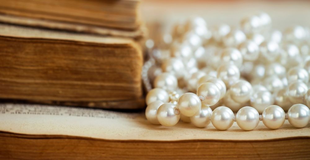 Perlen liegen auf einem alten Buch.