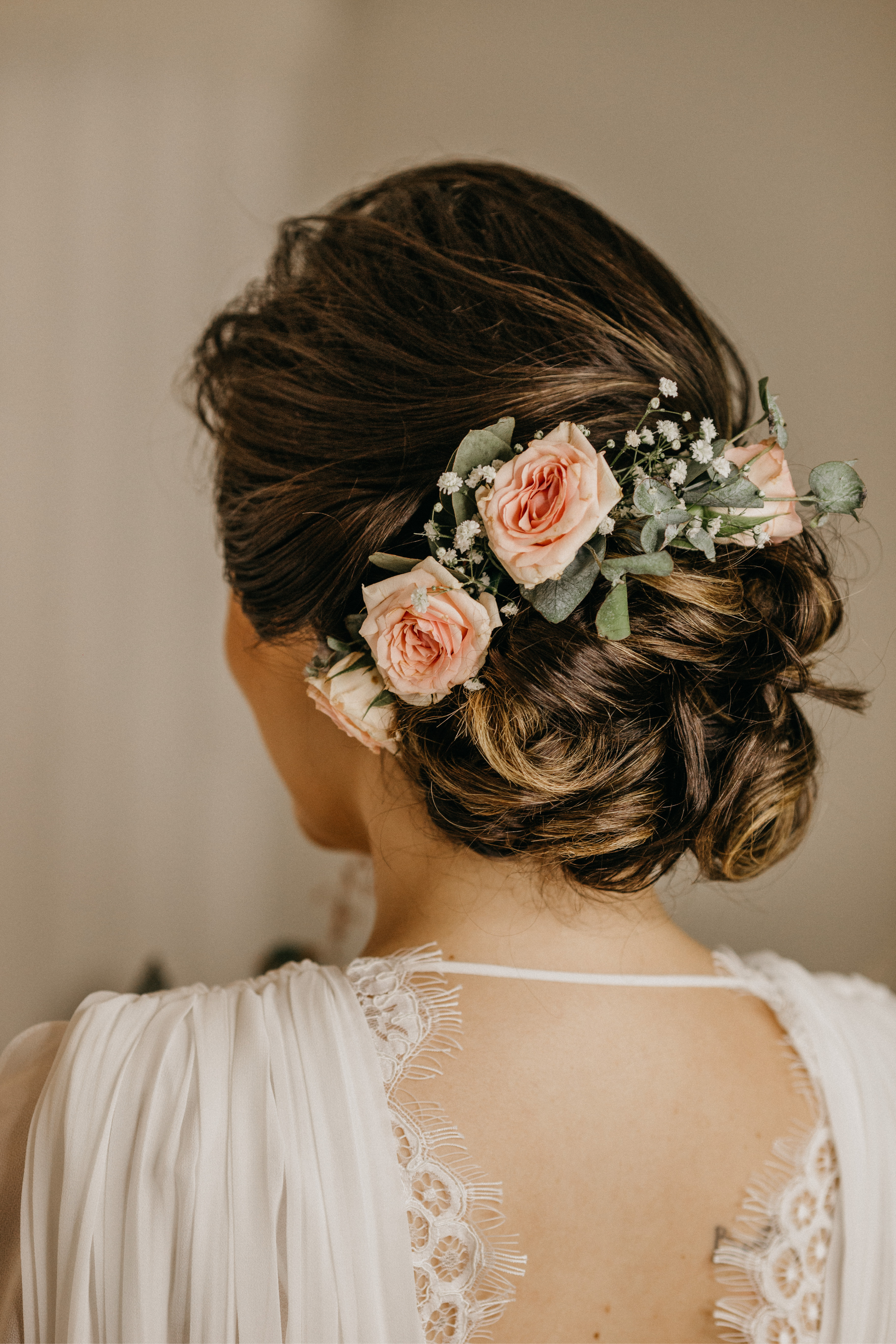 Die Braut trägt eine Brautfrisur mit Blumen.
