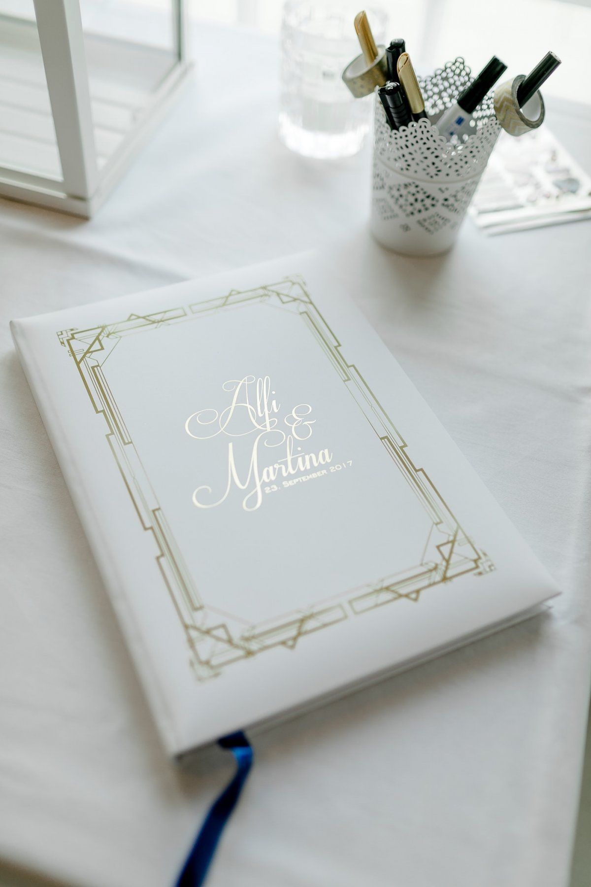Ein Hochzeitsbuch mit weißem Einband und goldener Beschriftung.