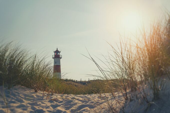 Ein Leuchtturm im Sand an einem sonnigen Tag.