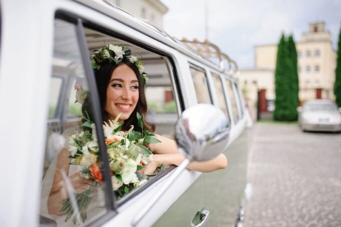 Eine Braut in einem VW-Wohnmobil mit Blumen im Haar.