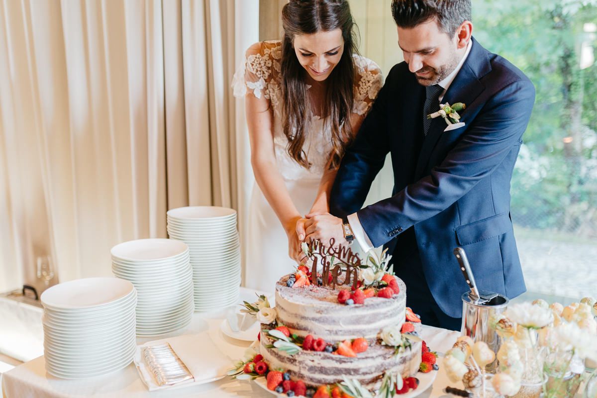 Eine Braut und ein Bräutigam schneiden ihre Hochzeitstorte an.