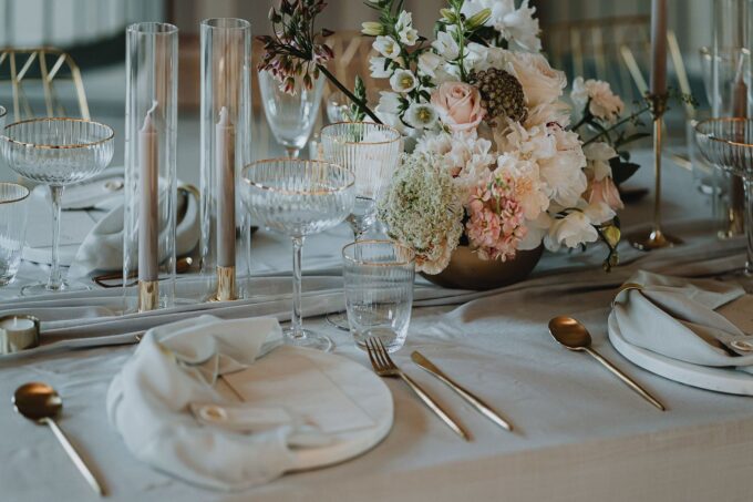 Ein gedeckter Tisch mit goldenen und weißen Tellern und Besteck.