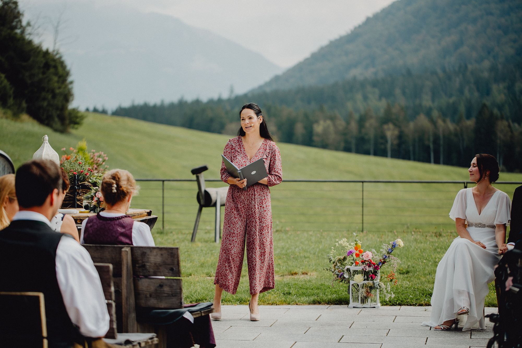 Eine Frau hält eine Rede bei einer Hochzeitszeremonie in den Bergen.