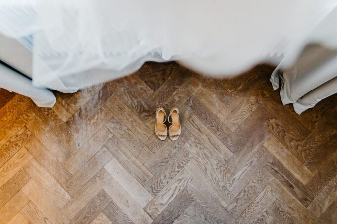 Die Schuhe einer Braut auf einem Holzboden.