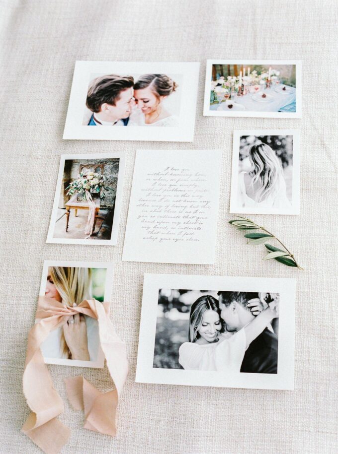 Hochzeitseinladungen mit Fotos und Bändern auf einem Tisch.