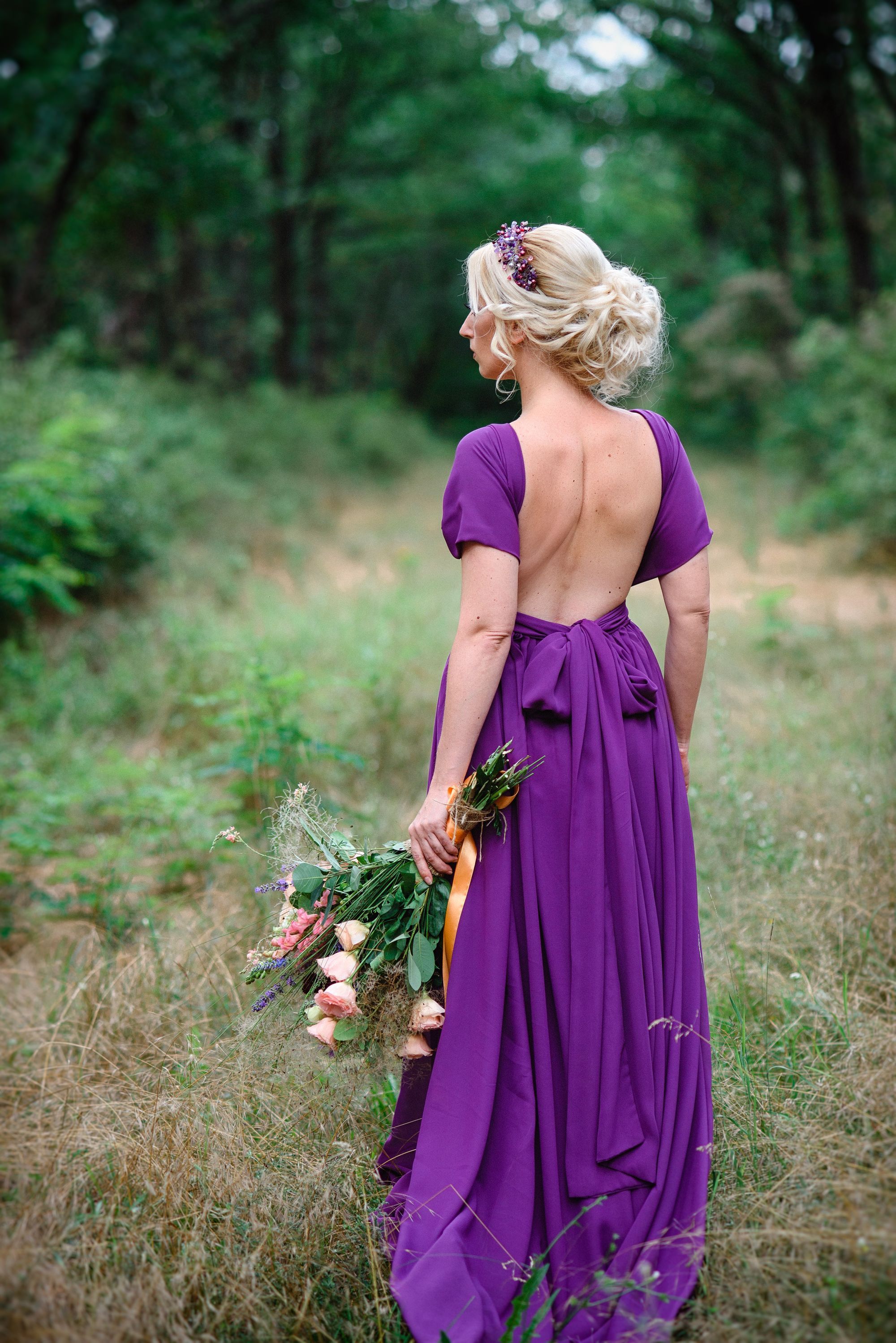 Die Braut trägt ein lilafarbenes Hochzeitskleid.