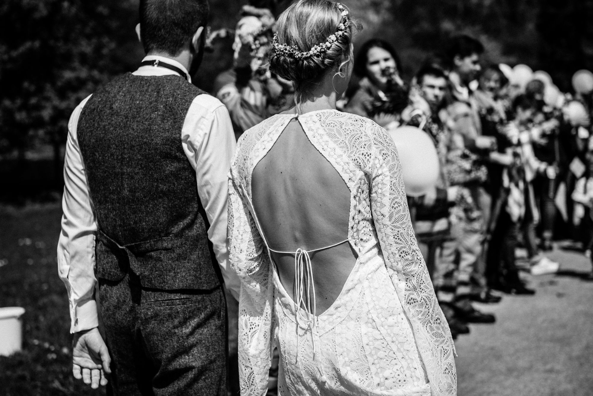 Schwarz-weiß-Aufnahme eines Brautpaares von hinten.