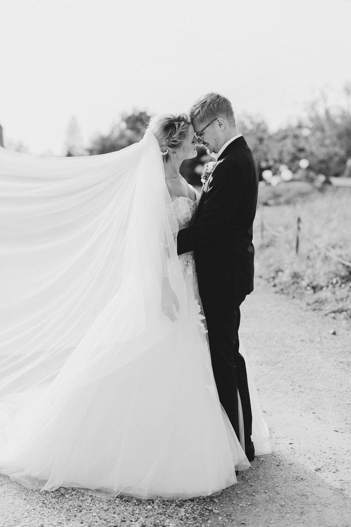 Schwarz-weiß-Aufnahme eines Brautpaares, das sich eng umschlungen gegenüber steht.