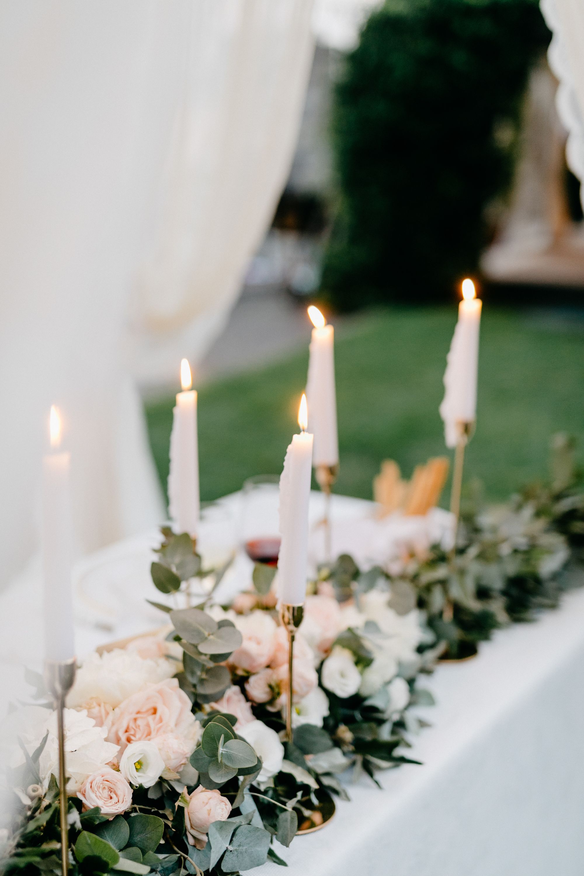 Kerzen und Blumen schmücken die Hochzeitstafel.