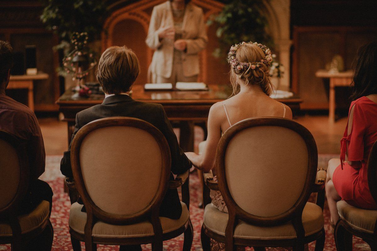 Eine Braut und ein Bräutigam sitzen bei einer Hochzeitszeremonie auf Stühlen.