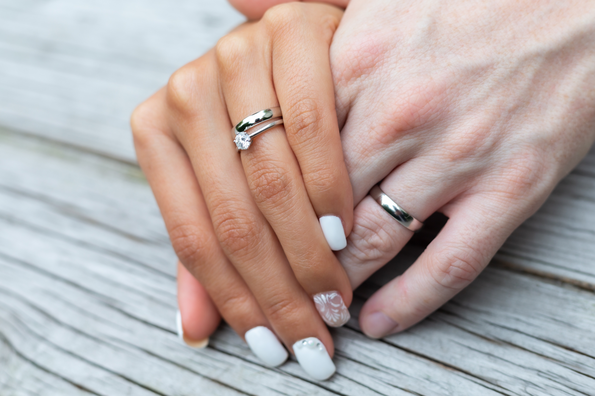Die Braut trägt auf ihren Nägeln weißen Nagellack.