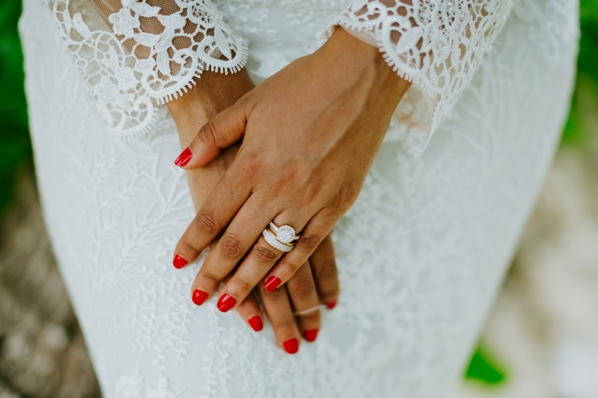Die Braut trägt auf ihren Nägeln roten Nagellack.