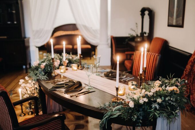 Ein mit Kerzen und Blumen gedeckter Tisch.