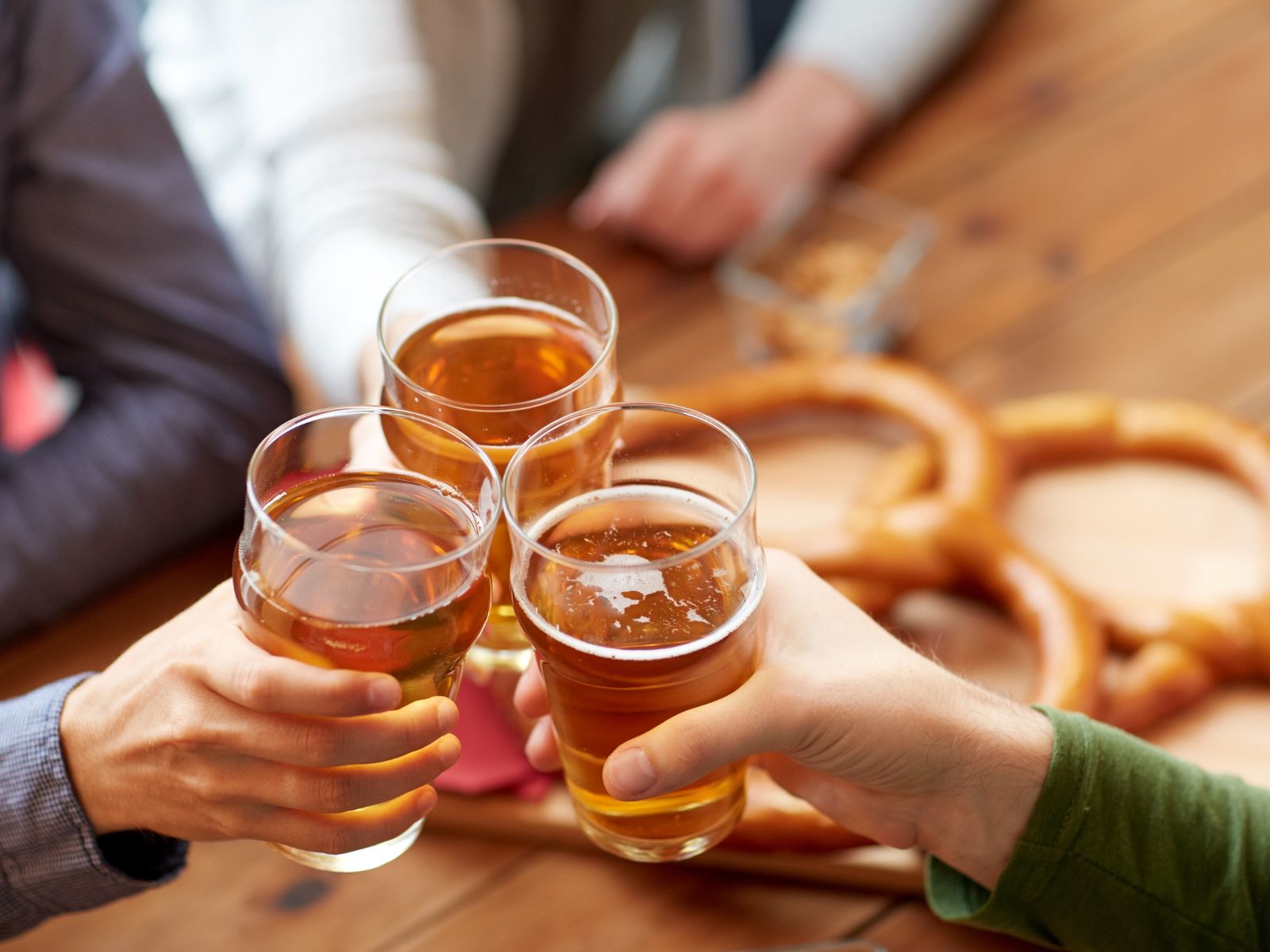 Das Bild fängt den geselligen Moment ein, in dem Freunde mit Bier auf gemeinsame Erlebnisse anstoßen.