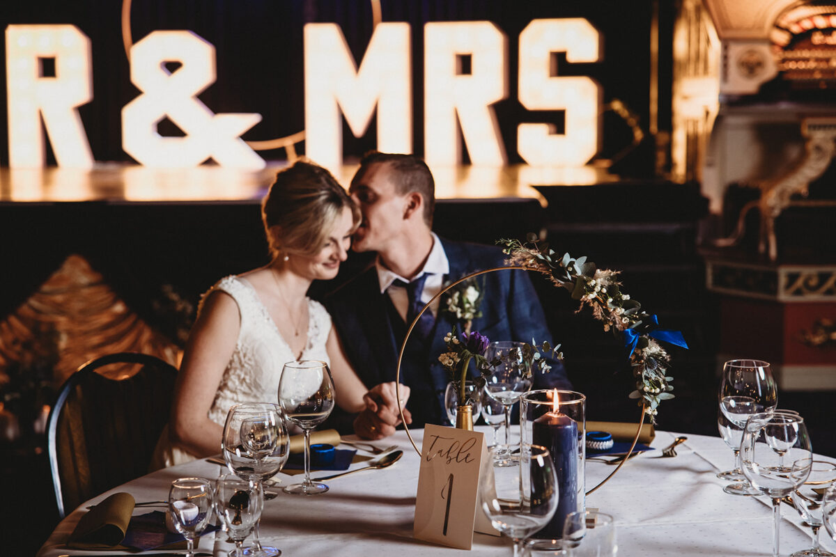 Eine Braut und ein Bräutigam sitzen an einem Tisch.
