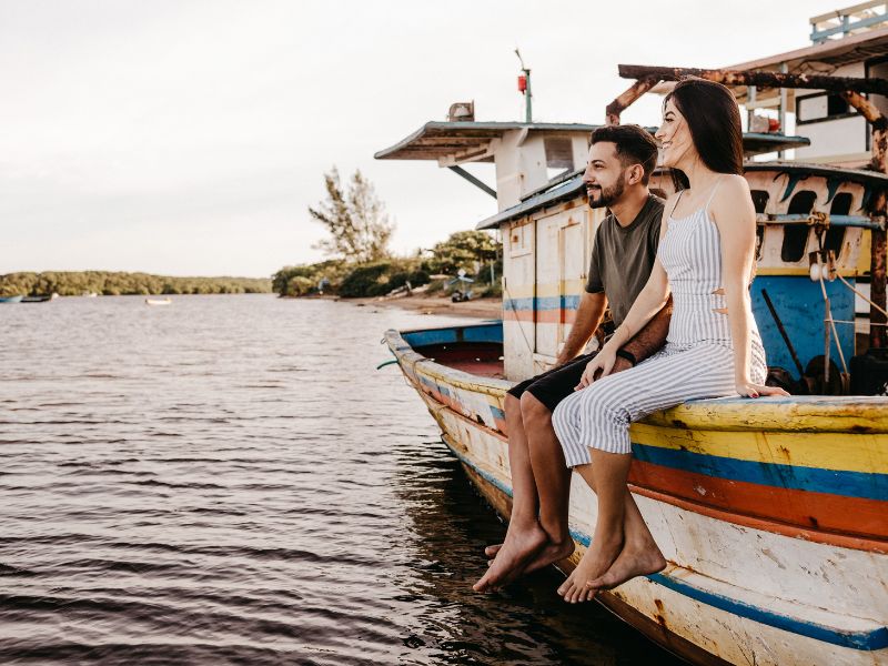 Das Paar sitzt gemeinsam auf einem Boot.