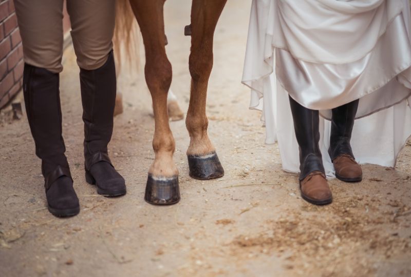 Der Bräutigam und die Braut tragen Reitstiefel.