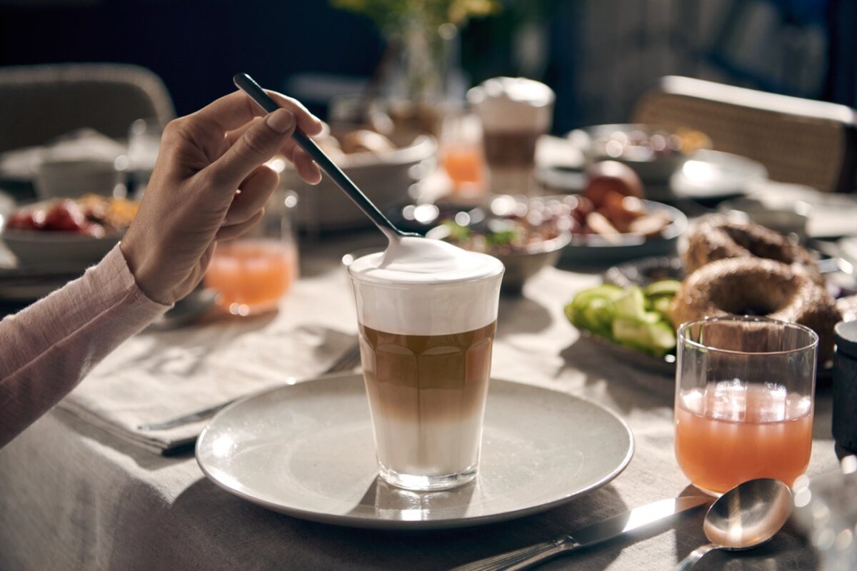 Eine Person gießt eine Tasse Kaffee auf einen Teller.