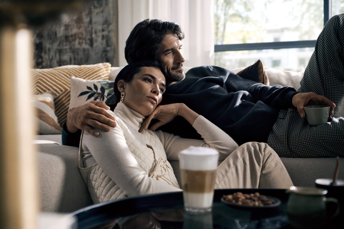 Ein Mann und eine Frau sitzen auf einer Couch im Wohnzimmer.