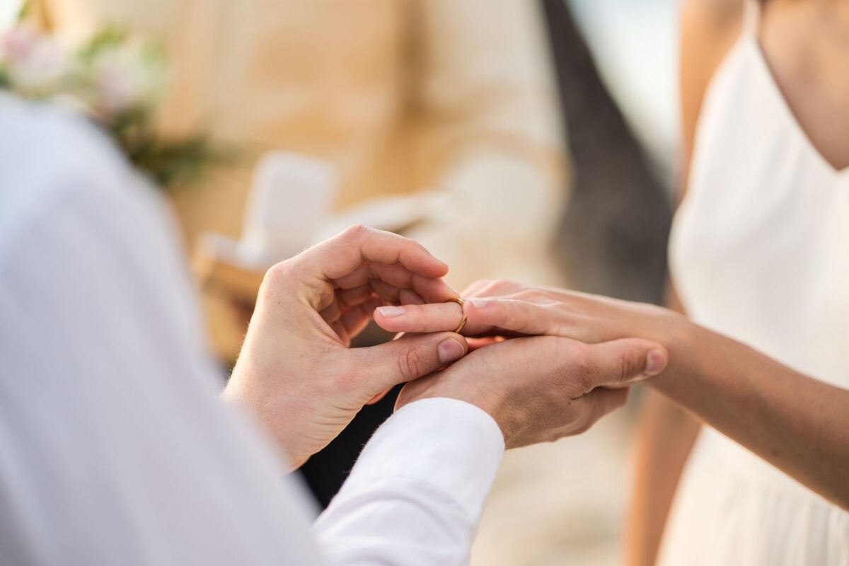 Paar tauscht Ringe während der Hochzeitszeremonie an Bord eines AIDA Schiffes.