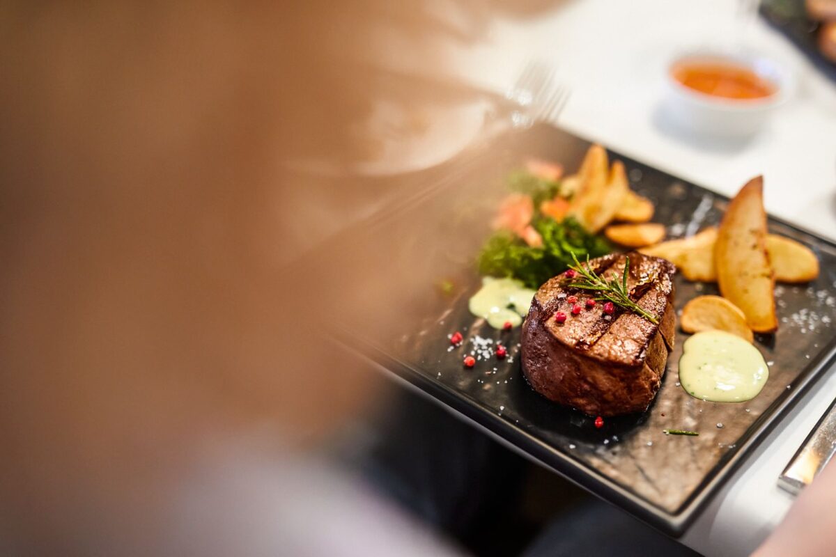 Gedeckter Tisch mit einem Hauptgericht in einem AIDA Restaurant.