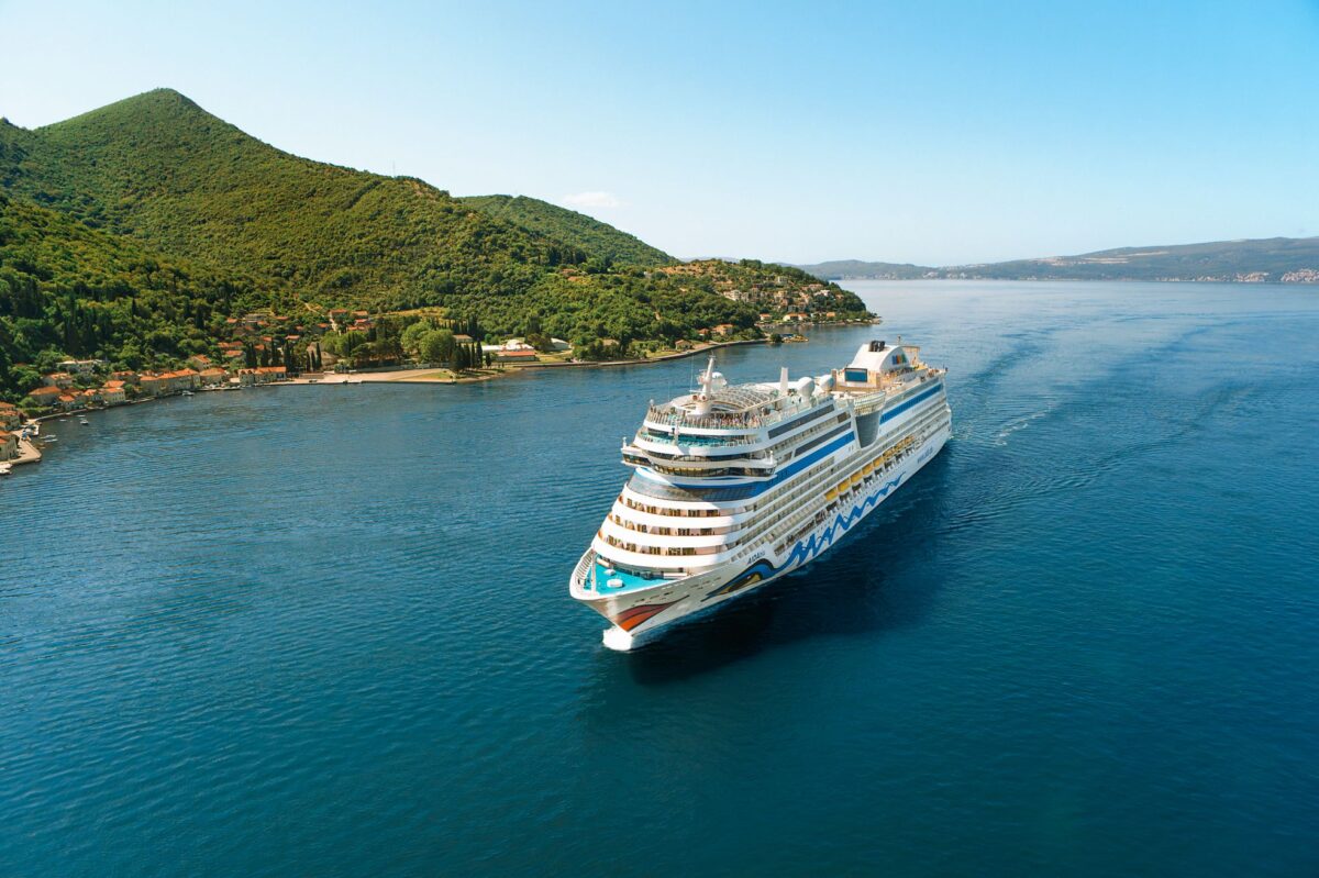 AIDA Kreuzfahrtschiff auf offenem Meer unter blauem Himmel.