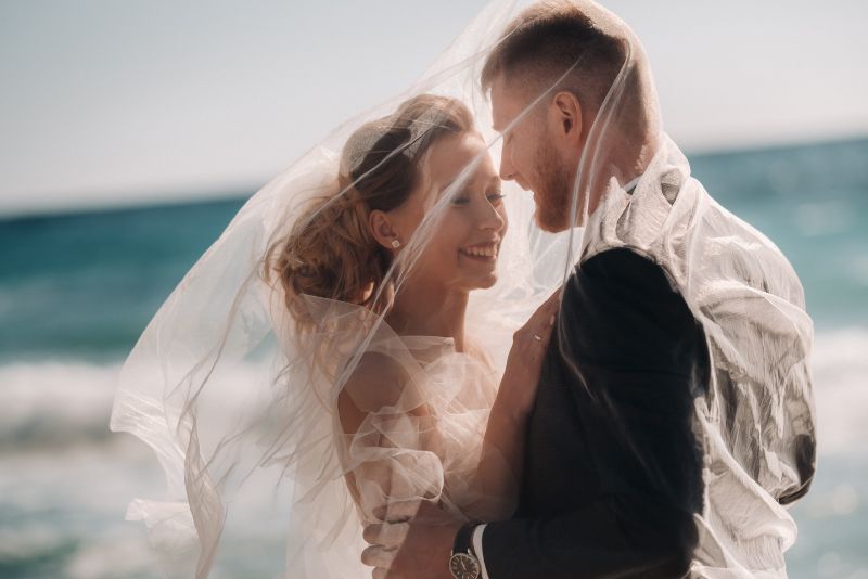 Glückliches Brautpaar am Hochzeitstag unter dem Schleier