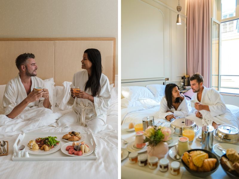 Paar sitzt zusammen im Hotelbett mit Room Service-Frühstück