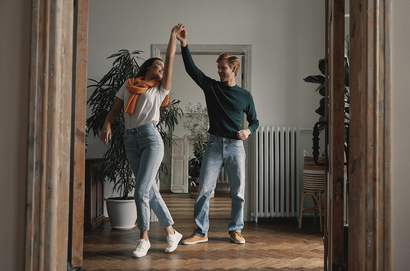 Junges Paar tanzt zu zweit im Wohnzimmer