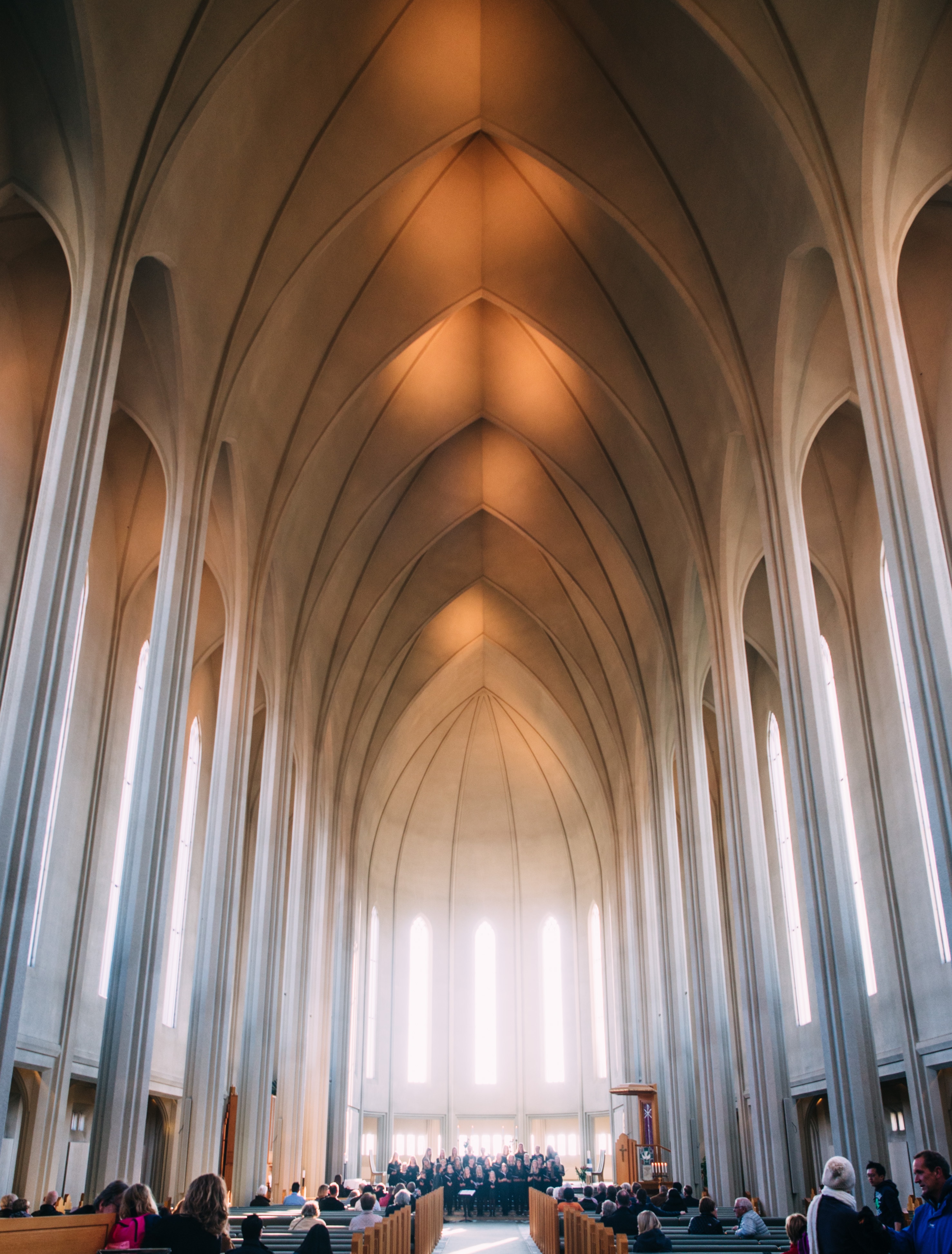 Das Innere einer Kirche mit Menschen, die in den Kirchenbänken sitzen.