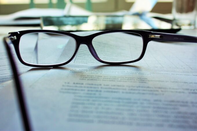 Eine Brille liegt auf einem Blatt Papier.