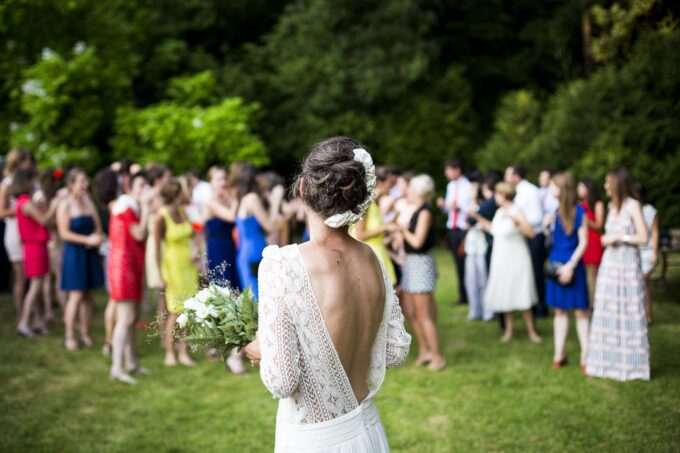 Eine Braut steht vor einer Menschenmenge.