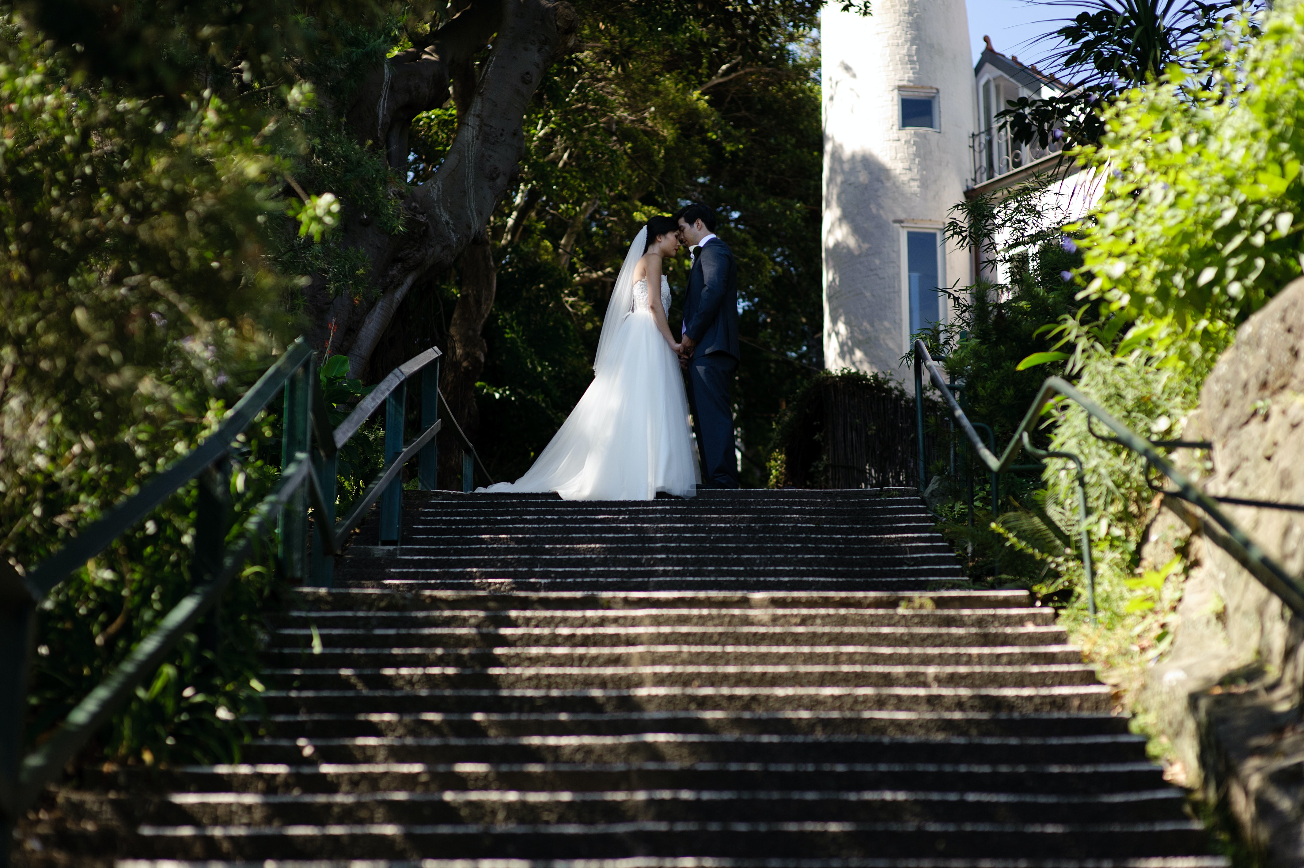Eine Braut und ein Bräutigam stehen auf den Stufen eines Leuchtturms.