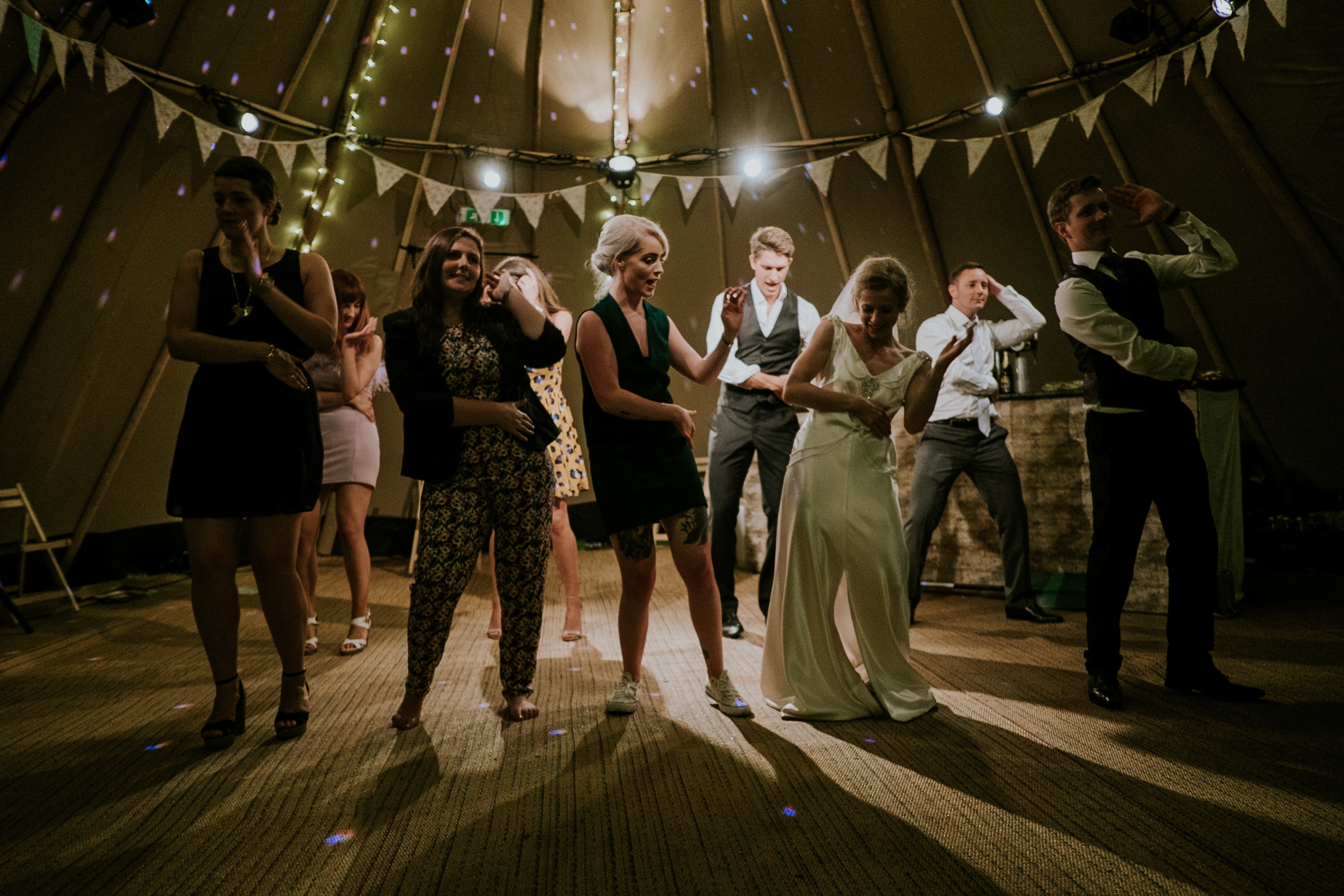 Eine Gruppe von Menschen tanzt in einem Zelt.