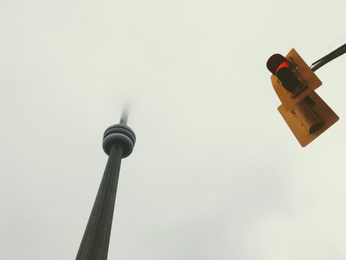 Eine Ampel und ein CN-Turm an einem bewölkten Tag.