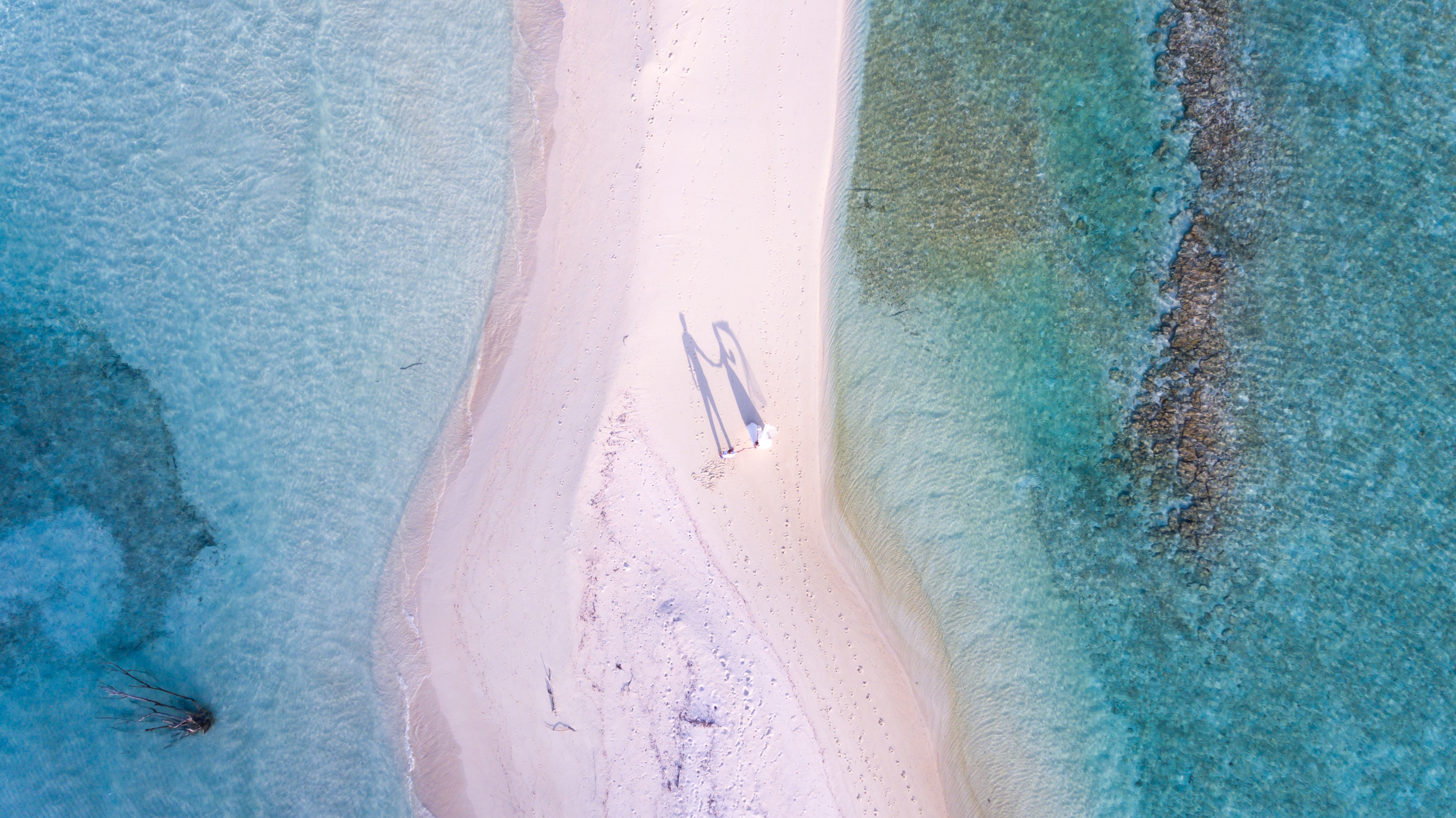 Eine Luftaufnahme eines weißen Sandstrandes.