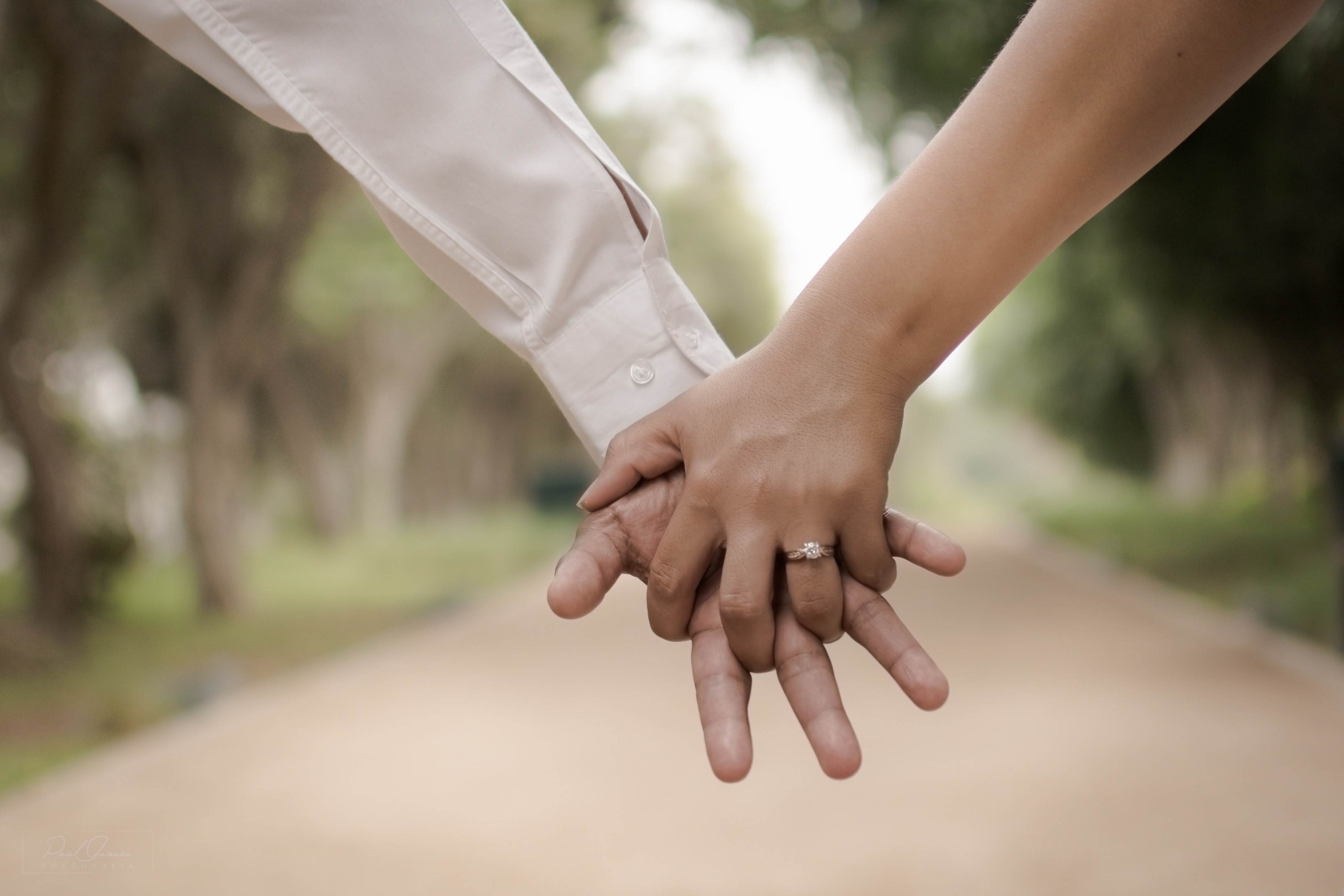 Ein Mann und eine Frau halten sich an den Händen auf einem Weg.