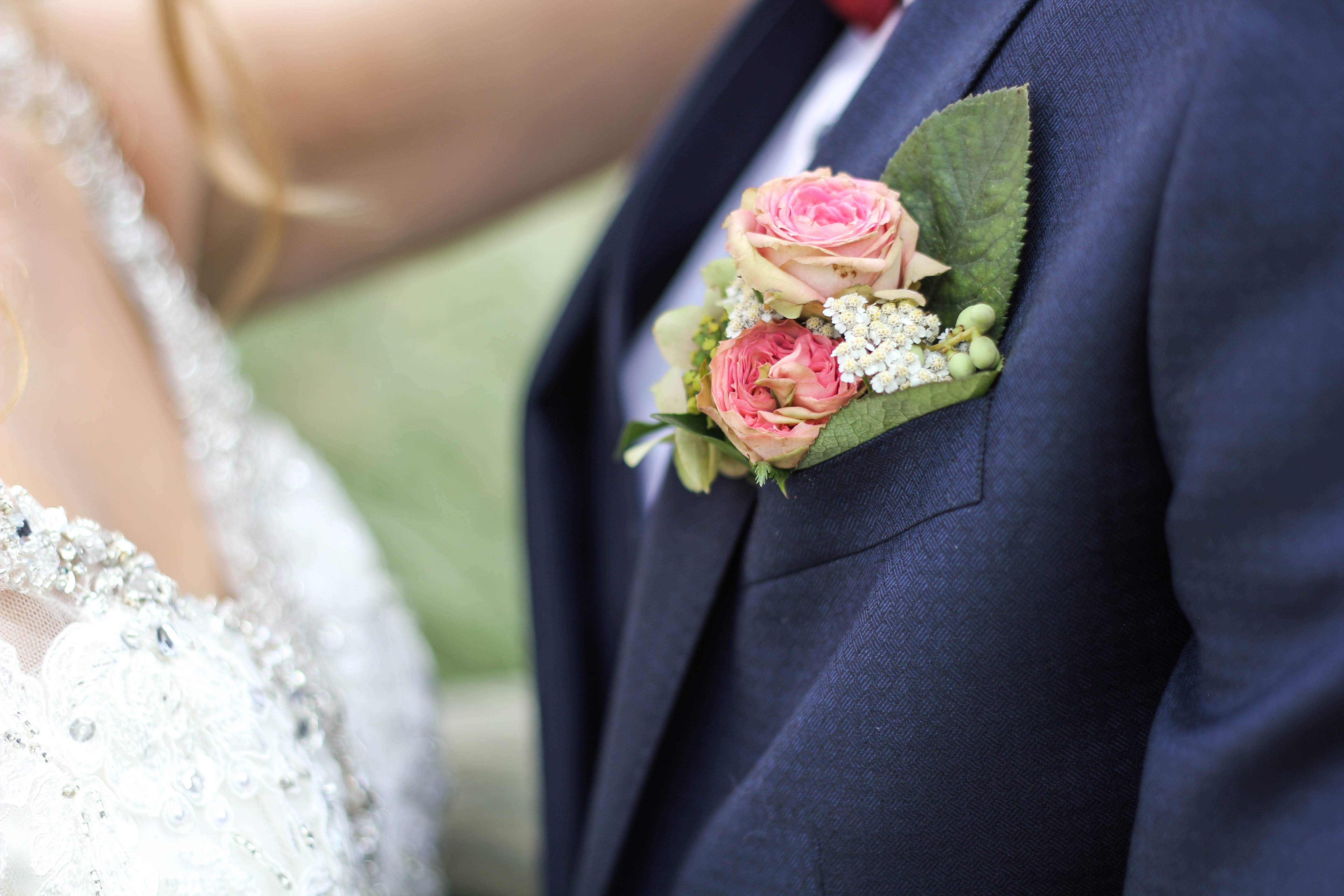 Eine Braut im Anzug mit einer Blume am Revers.