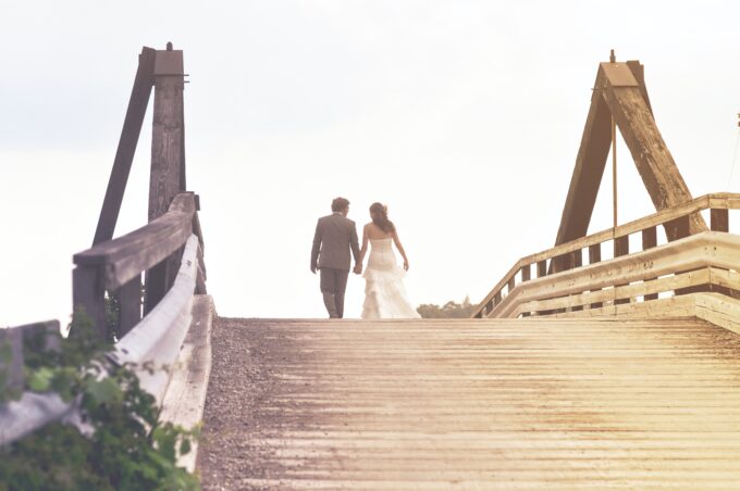 Eine Braut und ein Bräutigam gehen über eine Brücke.